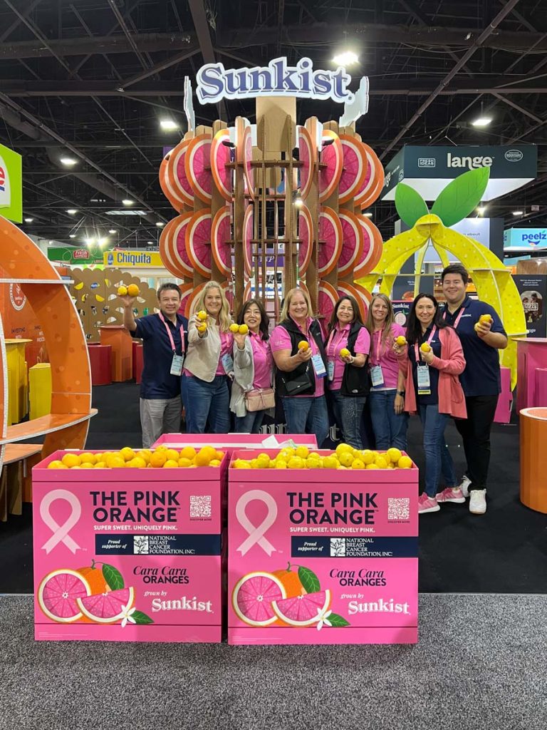 Workers posing behind customized cardboard display stands