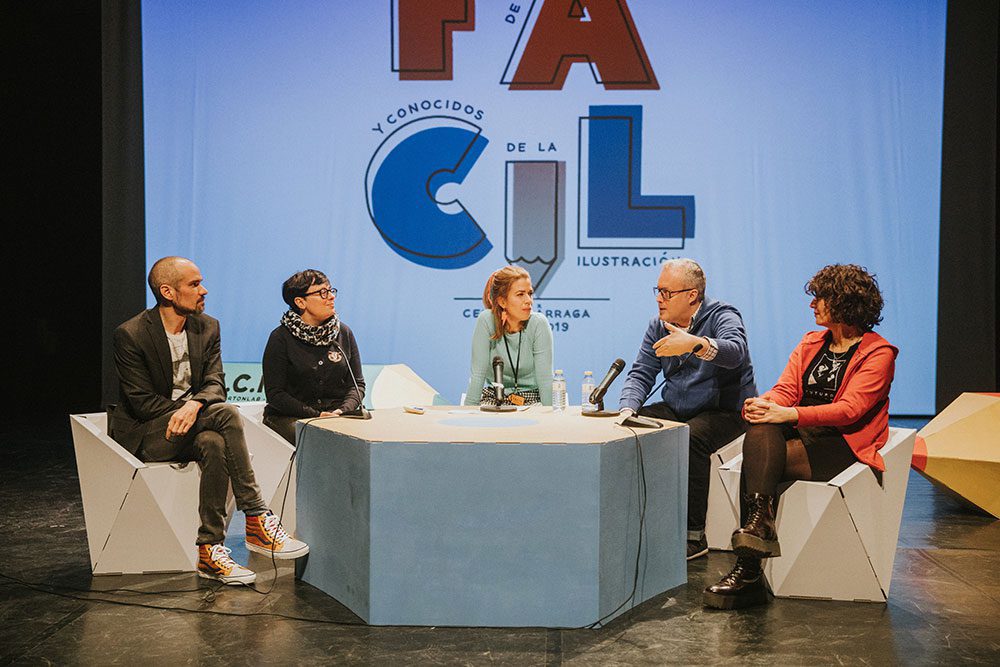 Los ponentes sentados en sillas faceta junto a mesa hexagonal