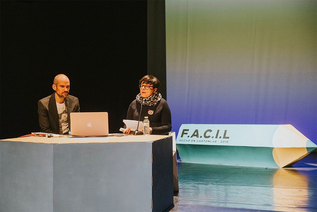 Dos de los ponentes junto a la figura personalizada del lapiz