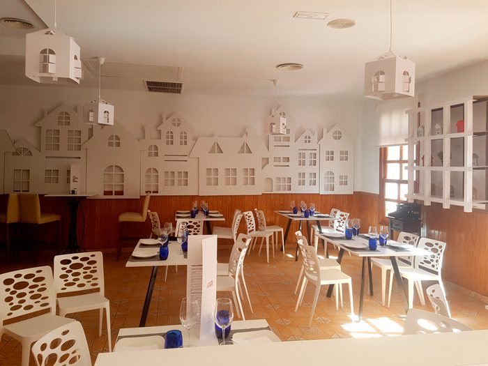 Vista del salón con estantería Ohm y pared con troqueles de fachadas