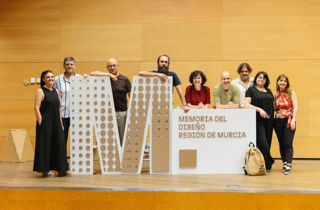 Miembros de DIP Murcia junto a mostrador personalizado de cartón